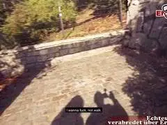 Mann mit schwarzer Lederjacke macht Selfie in sonniger Parkanlage mit Fluss und Bäumen im Hintergrund