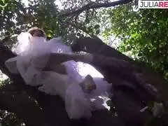 Blonde in weißem Tutu spreizt hoch im Baum die Beine und fingert ihre nasse Fotze