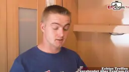 Junger Mann im blauen Shirt schaut überrascht in der Küche